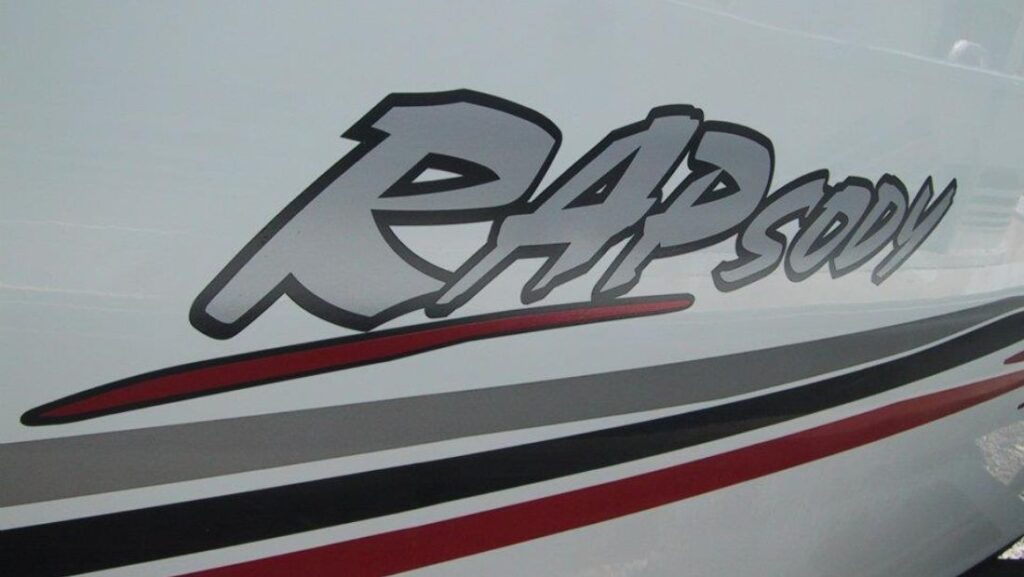 Marine vinyl boat wrap with bold “Rapsody” custom graphics and sleek stripe accents on a white hull, showcasing a clean and dynamic wrap design.