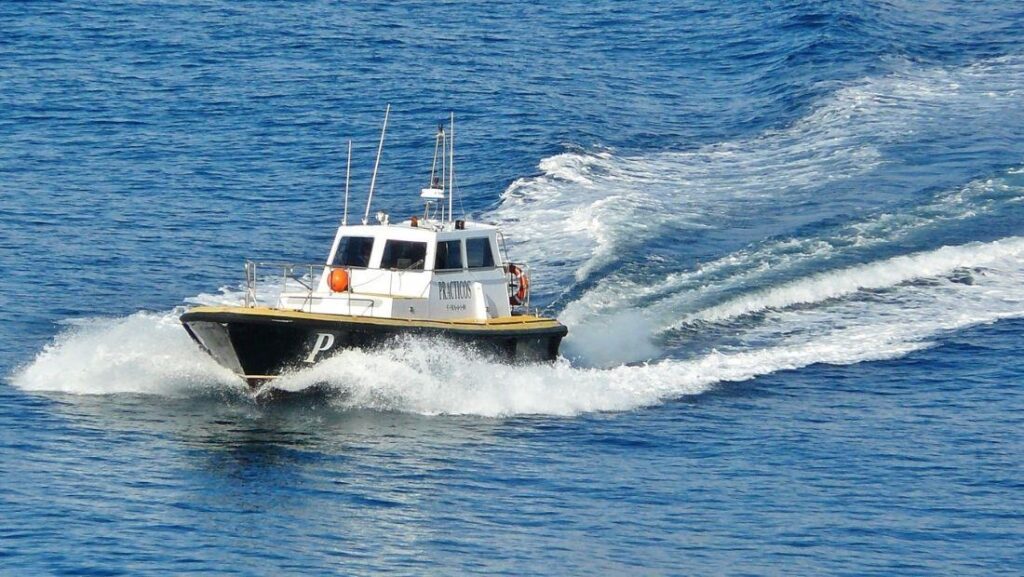 Small workboat moving across open water with a clean hull finish