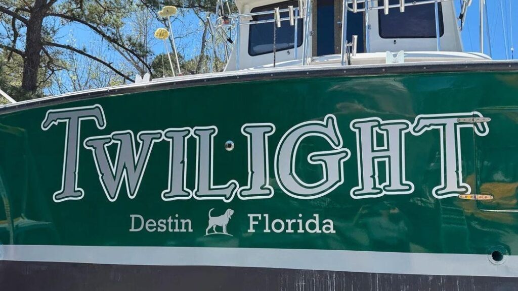 Custom “Twilight” boat lettering with Destin, Florida text on a green boat hull.
