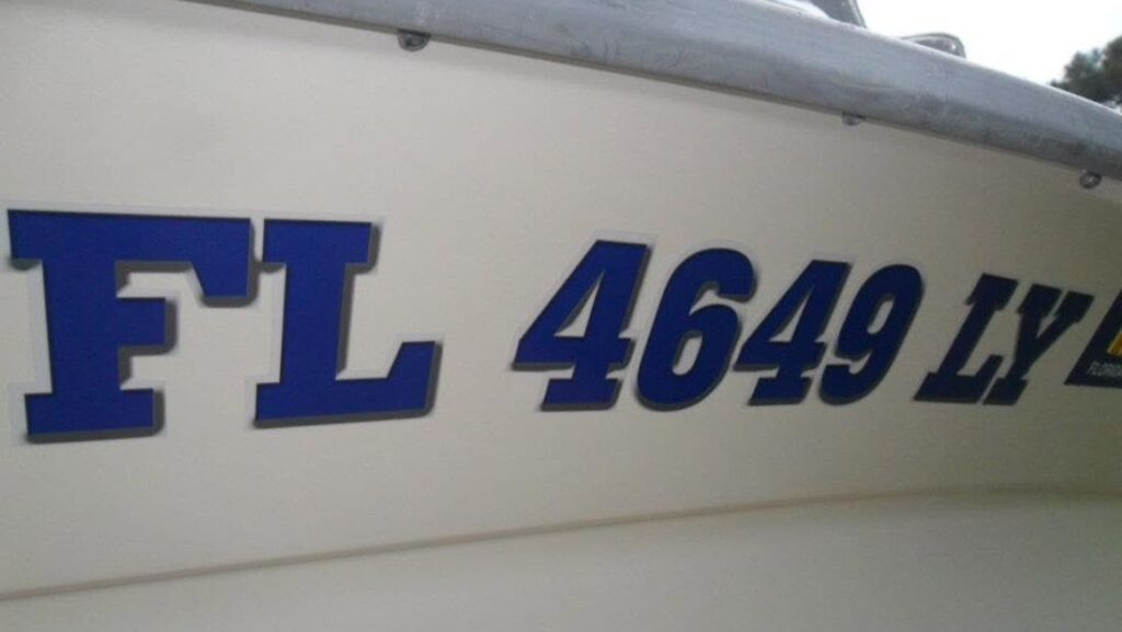 Close-up of blue and black Florida boat registration numbers on a white hull.