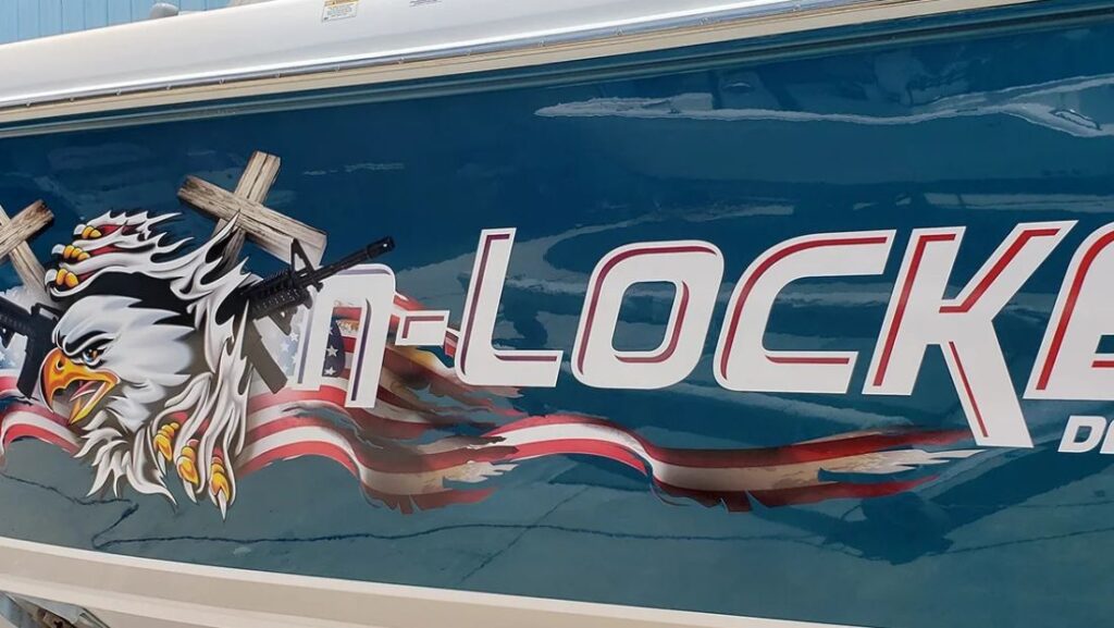 Custom boat graphic with an eagle, American flag artwork, and large outlined lettering on a blue hull