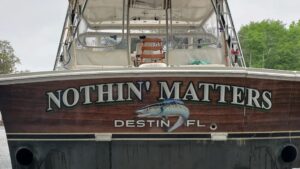 Boat stern with “Nothin’ Matters” lettering, fish artwork, and Destin, Florida hailing port