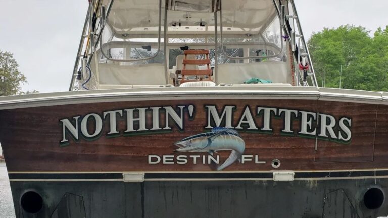 Boat stern with “Nothin’ Matters” lettering, fish artwork, and Destin, Florida hailing port